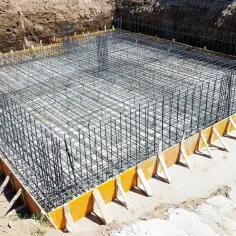 Szkielet zbrojeniowy fundamentów, gotowy do zalania betonem. To kluczowy etap, by wiedzieć, jak obliczyć stal na fundamenty.