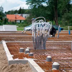 Przygotowanie terenu pod budowę: jak położyć fundament. Widoczne zbrojenie, rury i izolacja.