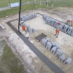 Pracownicy wylewają beton, pokazując, jak wybudować fundamenty. Betonowa pompa i bloczki budowlane na placu budowy.