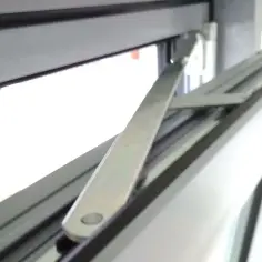 Mechanizm okna uchylnego do mycia. Metalowe ramię połączone z ramą okna, umożliwiające otwarcie skrzydła w pozycji uchylnej.