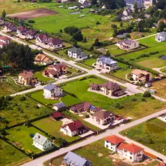 Osiedle domów jednorodzinnych z drogami. Zastanawiasz się, ile kosztuje wytyczenie drogi dojazdowej do takiej posesji?