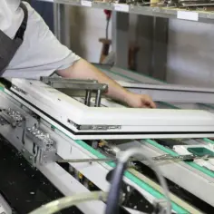Pracownik montuje okno, tworząc je dla jednych z najwięksi producenci okien w polsce.
