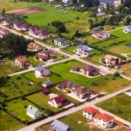 Osiedle domów jednorodzinnych z drogami. Zastanawiasz się, ile kosztuje wytyczenie drogi dojazdowej do takiej posesji?
