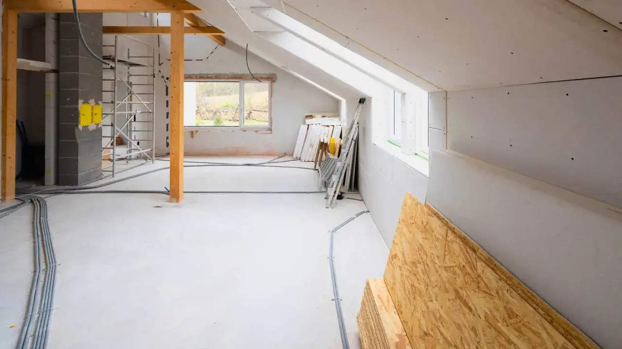 Budowa dobudówki do domu w toku. Widać rusztowania, materiały budowlane i instalacje. Zastanawiasz się, ile kosztuje dobudówka do domu?